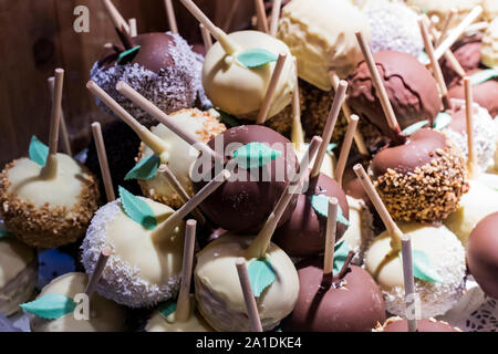 Früchte, Bananen, Erdbeeren, Nüsse, Äpfel, Pfirsiche in weißer und dunkler Schokolade getaucht. Stockfoto