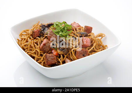 Chinesische Nudeln mit Fleisch und Sojasauce in einer weißen Schüssel Stockfoto