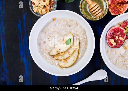 Eine Schüssel Haferbrei mit Birnen und Walnüssen und Haferbrei mit Feigen Stockfoto