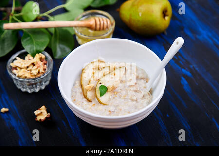 Eine Schüssel Haferbrei mit Birnen und Walnüssen. Stockfoto