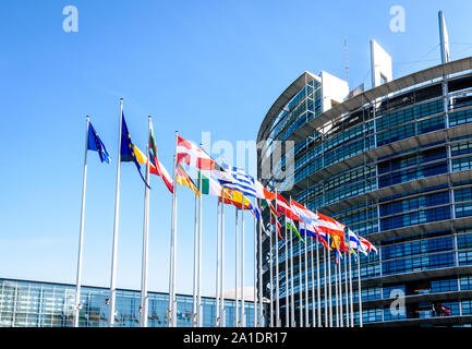 Flaggen der Mitgliedstaaten der Europäischen Union winken vor dem Eingang des Gebäudes des Europäischen Parlaments in Straßburg, Frankreich. Stockfoto