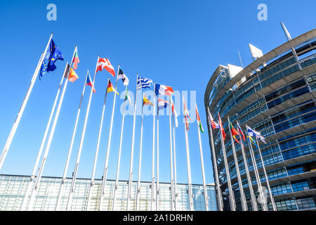 Flaggen der Mitgliedstaaten der Europäischen Union winken vor dem Eingang des Gebäudes des Europäischen Parlaments in Straßburg, Frankreich. Stockfoto