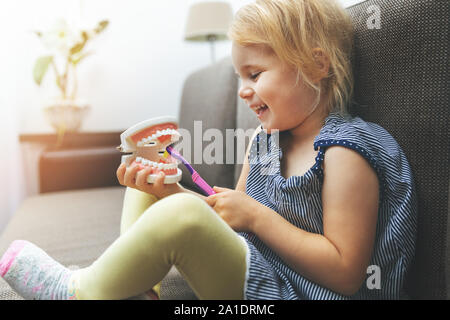 Kind zahnmedizinische Gesundheit - kleines Mädchen Training am Modell, wie die Zähne richtig zu putzen Stockfoto