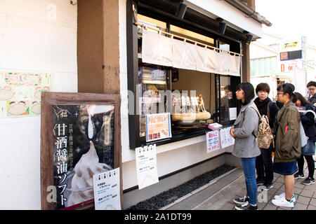 TOKYO, Japan - 31. März: Japanische Leute und fremde Reisende stehen für kaufen Dango oder Japanischen Kloß und Süßes aus mochiko auf Stockfoto