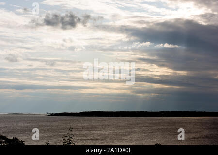 Die untergehende Sonne durch die Wolken, auf Mackinac Island, Michigan gesehen. Stockfoto