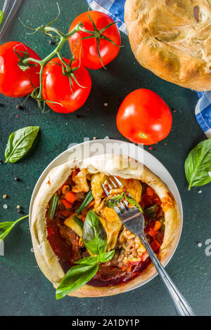 Zwei Teil hausgemachte Chicago Pizza Pot Pie mit Käse, Hackfleisch, Fleisch und Gemüse, mit Töpfen und Zutaten, die in der Tabelle Platz kopieren Stockfoto