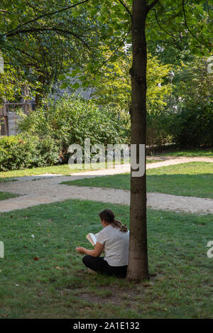 Frau liest in einem Park in Berlin, Deutschland. Stockfoto