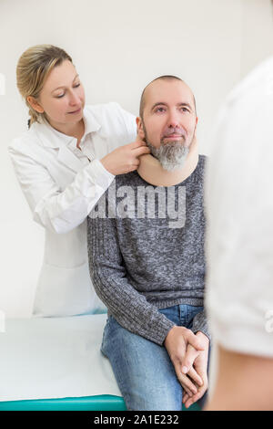 Männlicher Patient erhält eine weiche Kragen in einem Doktorbüro Stockfoto