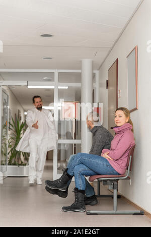 Arzt oder Chirurg gibt eine Frau ein Handshake im Flur oder Wartezimmer eine Klinik oder eine private Praxis Stockfoto