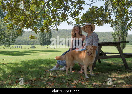 Eine australische Frau und ihrer Tochter und ihrem Hund zusammen sitzen Lächeln unter einen großen Baum am ehemaligen Gehöft des Künstlers Arthur Boyd Stockfoto