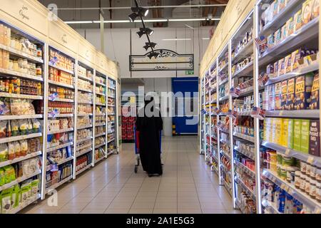 Eine verschleierte Frau schiebt einen Einkaufswagen in einem Supermarkt Carrefour, im Villagio Einkaufszentrum in Doha/Katar, am 25.09.2019. | Verwendung weltweit Stockfoto