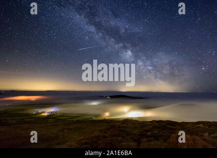 Dramatische meer Nebel Rollen in über lokale Betriebe bei Nacht mit der Milchstraße Overhead auf dem lleyn Halbinsel im Norden von Wales aus Uwchmynydd gesehen. Stockfoto