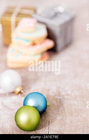 Weihnachtskugeln, Geschenkboxen und Cookies auf Holztisch, Grußkarte Stockfoto