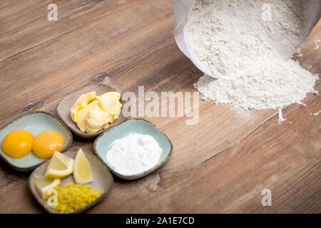 Zutaten für eine hausgemachte Plätzchen oder Kuchen Teig, Mehl auf dem hölzernen Tisch Stockfoto
