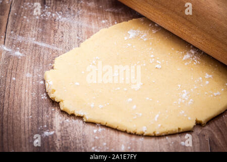 Frische rohe Plätzchenteig und Rolling Pin auf Holztisch, Konzept Weihnachtsbäckerei Stockfoto
