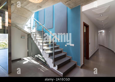 Treppen im Inneren des modernen konkrete Haus mit blauen Wand und Leuchte. Stockfoto