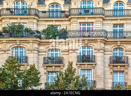 Blick auf die Straße von einem alten, eleganten Gebäude Fassade in Paris, mit kunstvollen Details in den Steinmauern und französische Fenster. Stockfoto