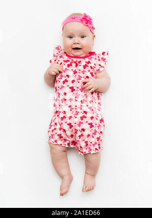 Porträt von einem süßen baby baby Mädchen trägt ein rosa Kleid und Kopfband Bogen, auf Weiß in Studio isoliert. Stockfoto