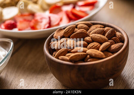 Mandeln in Houten mit yoguth und die Platte von gesundes Frühstück Stockfoto