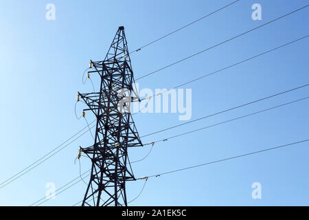 Metall pylon einer Hochspannungsleitung mit Glas Isolatoren und Kabel auf einem Hintergrund von den klaren, blauen Himmel Stockfoto