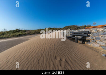 Wind ausgeblasen Strand sand Abdeckungen aus recyceltem Kunststoff Sitzbänken in einem neuen Dune. Port Eynon, Gower, AONB, Swansea, Wales, Halbinsel Gower, Stockfoto