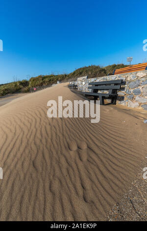 Wind ausgeblasen Strand sand Abdeckungen aus recyceltem Kunststoff Sitzbänken in einem neuen Dune. Port Eynon, Gower, AONB, Swansea, Wales, Halbinsel Gower, Stockfoto