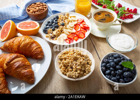 Gesundes Frühstück serviert mit Platte von Joghurt Müsli Blaubeeren Erdbeeren und Bananen. Stockfoto