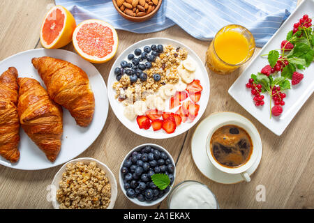 Gesundes Frühstück serviert mit Platte von Joghurt Müsli Blaubeeren Erdbeeren und Bananen. Stockfoto