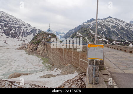 Grimsel Hospiz, Obere Haslital, Schweiz - 18. Juni 2019: Bushaltestelle in der Nähe des gefrorenen Grimselsee Dam (grimselsee) Baustelle in der Nähe von Grimsel Pas Stockfoto