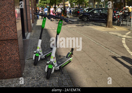 Frankfurt am Main, Deutschland. August 2019. Elektroroller für mieten. Sie gefunden werden, rund um die Stadt geparkt, in Weiß und Grün. Stockfoto