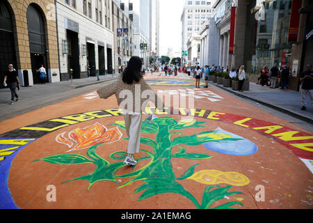 (190926) - SAN FRANCISCO, Sept. 26, 2019 (Xinhua) - Eine Frau geht auf den Boden malen themed zum Umweltschutz bei Montgomery Street in San Francisco, USA, Sept. 25, 2019. Insgesamt 13 Boden Gemälde themed zum Umweltschutz wurden am Mittwoch in San Francisco erstellt für die Reduzierung der Nutzung fossiler Brennstoffe, sowie Investitionen in grüne Energie zu nennen. (Foto von Xinhua/Li Jianguo) Stockfoto