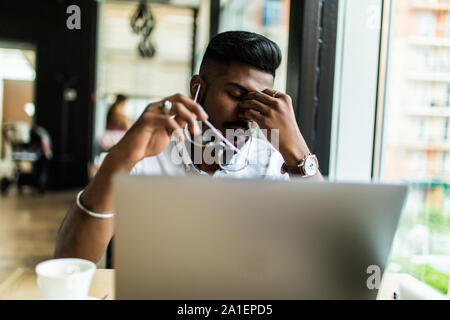 Junge asiatische Geschäftsmann leiden müde Augen nach langen Stunden des Laptop verwenden. Stockfoto