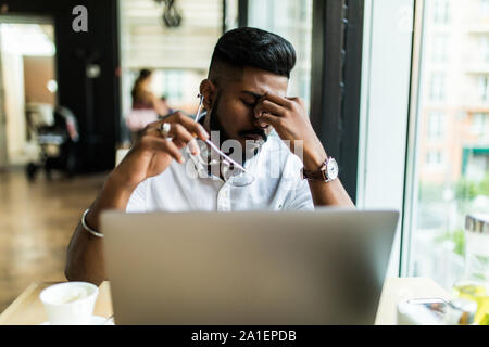 Junge asiatische Geschäftsmann leiden müde Augen nach langen Stunden des Laptop verwenden. Stockfoto