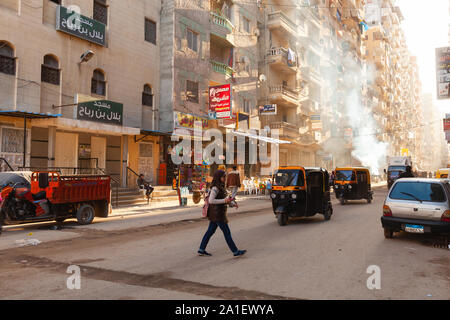 Alexandria, Ägypten - Dezember 18, 2018: Alexandria street view, gewöhnliche Menschen zu Fuß die Straße mit Auto-rikschas und Autos Stockfoto