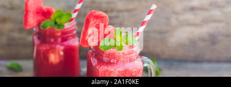 BANNER gesunde Wassermelone Smoothie in Maurergläser mit Minze und gestreifte Trinkhalme auf einem Holz Hintergrund. Lange Format. Stockfoto