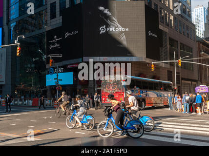 Eine riesige digitale Anzeige in der Times Square in New York am Donnerstag, 26. September 2019 zeigt Videos für den Börsengang der at-home Fitness Company Company Peloton Interaktiv. Peloton liefert Internet-fähigen Fahrräder und Laufbänder ermöglicht weltweite Athleten zum Streamen von Real-time-Klassen, oder aufgenommene Klassen je nach Zeitzone. (© Richard B. Levine) Stockfoto