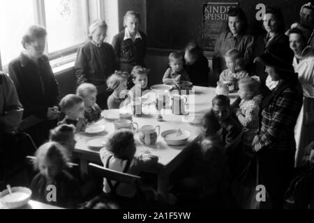 Kinder bekommen die Speisung durch die Canadian Lutheran World Relief in einer karitativen Einrichtung in Frankfurt/Oder, Deutschland 1948. Kinder erhalten die Fütterung durch die Canadian Lutheran World Relief an einer Nächstenliebe station in Frankfurt an der Oder, Deutschland 1948 gefördert. Stockfoto