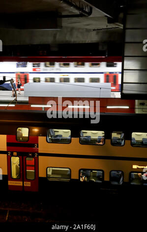 Zürich, Schweiz, 22. Juli 2019: Plattformen der Züricher Hauptbahnhof bei Nacht, Ansicht von oben, Zug vor der Station mit wenigen Menschen Stockfoto