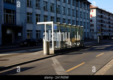 Zürich, Schweiz, 22. Juli 2019: leeren Bus Station und leere Straße in Zürich im sonnigen Morgen Bushaltestelle an einer Bushaltestelle aus Glas Stockfoto