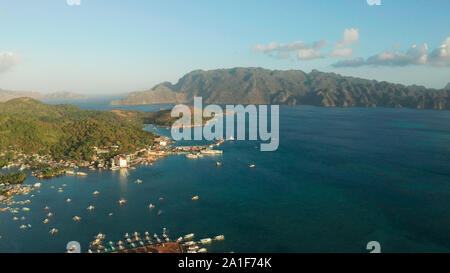 Luftaufnahme Coron Stadt mit Slums und Armenviertel. Hafen, Seebrücke, stadtbild Coron Town mit Booten auf Busuanga Island, Philippinen, Palawan. Marine mit Bergen. Stockfoto