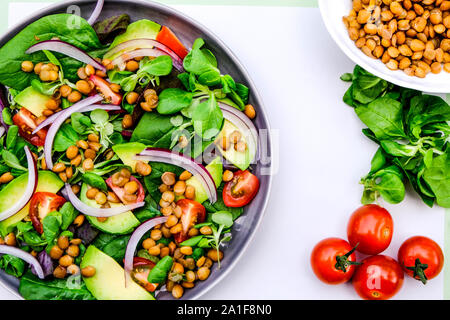 Gesunde vegetarische oder vegane Avocado- und Linsensalat, mit roten Zwiebeln, grüner Salat Blätter andcopy Raum, Cherry Tomaten Stockfoto