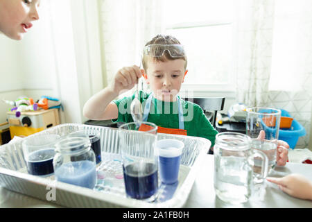 Elementare alter Junge konzentriert tun Chemie Science Experiment zu Hause Stockfoto