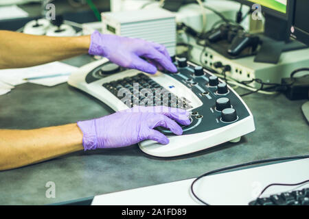 Hände von einem Wissenschaftler auf einem Control Panel von einem Elektronenmikroskop. Stockfoto