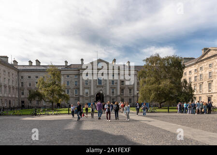 Die Menschen auf den Parliament Square am Trinity College Dublin mit Regent House im Hintergrund an einem sonnigen Tag Stockfoto