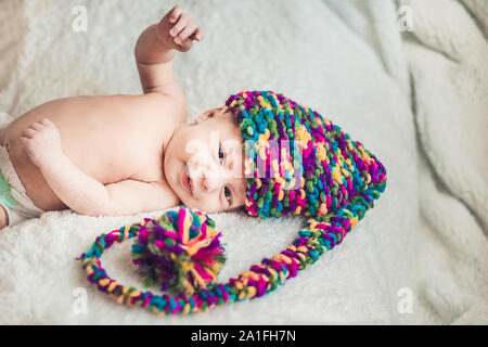 Neugeborenes Baby im Neuen Jahr gnome Cap liegt auf einer weißen Decke. Stockfoto