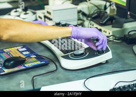 Hände von einem Wissenschaftler auf einem Control Panel von einem Elektronenmikroskop. Stockfoto