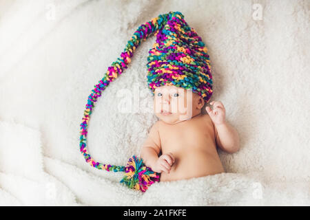 Neugeborenes Baby im Neuen Jahr gnome Cap liegt auf einer weißen Decke. Stockfoto