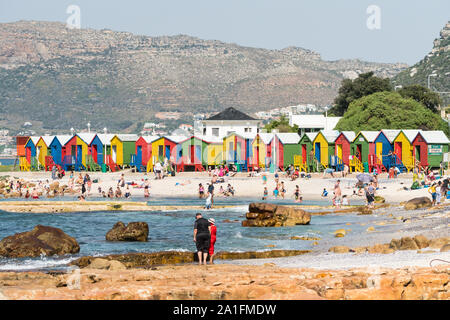 Holzhütten am St. James, Cape Peninsula, Cape Town, Südafrika, hell und farbenfroh, mit Scharen von Menschen oder beachgoers genießen Freizeit im Sommer Stockfoto