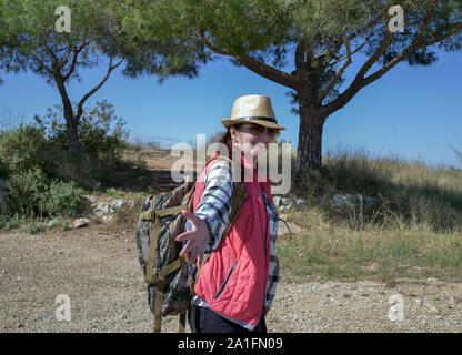 Happy girl touristische Wanderungen entlang einer Mountain Trail dreht sich um und hält seine Hand und folge mir nach! Stockfoto