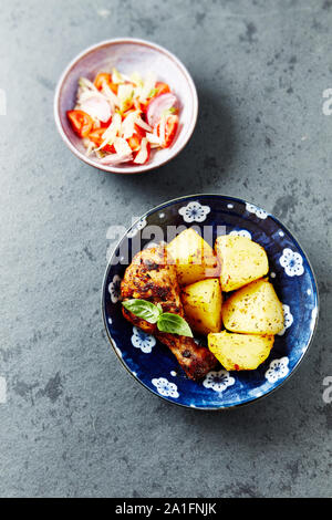 Gebratenes Huhn mit gebackenen Kartoffeln, Tomaten und Zwiebeln. Hausgemachte Speisen. Stockfoto